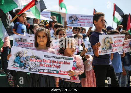 Gaza, Palestine. 24th Aug, 2021. Palestinian children hold banners during an event to send humanitarian messages to the world to end the siege of Gaza by Israel. Credit: SOPA Images Limited/Alamy Live News Stock Photo