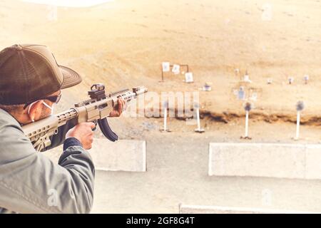 Men practicing shooting with a assault rifle at target. Selective Focus Stock Photo