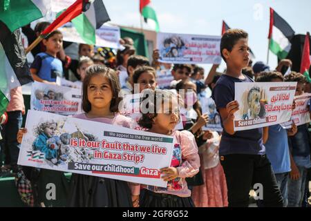 Gaza, Palestine. 24th Aug, 2021. Palestinian children hold banners during an event to send humanitarian messages to the world to end the siege of Gaza by Israel. (Photo by Ahmed Zakot/SOPA Images/Sipa USA) Credit: Sipa USA/Alamy Live News Stock Photo