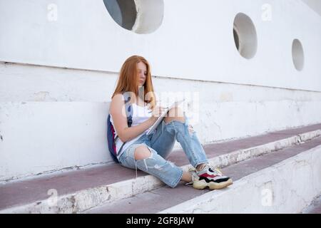 https://l450v.alamy.com/450v/2gf8jaw/teenage-girl-draws-in-the-sketchbook-while-sitting-on-the-steps-2gf8jaw.jpg