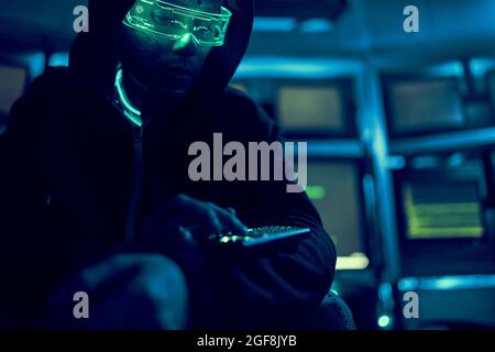 Cyber hacker breaks into databases to obtain information using a computer. Cybercrime and data security concept. Stock Photo