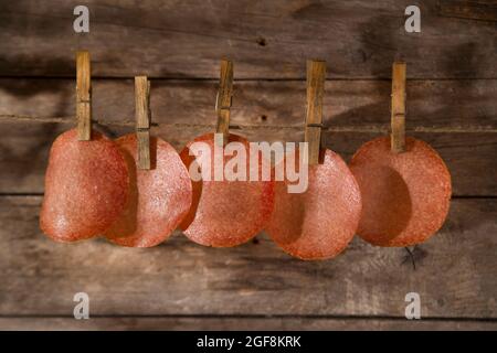 Presentation of slices of salami hanging by a thread Stock Photo