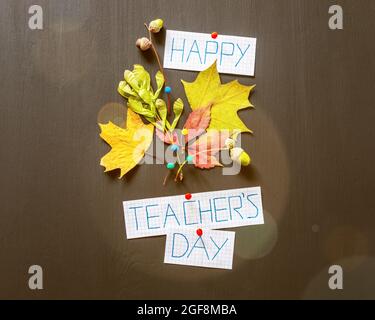 Teachers Day. Holiday, school composition with autumn bouquet, inscription happy teachers day on a black chalkboard with highlights. Hand made autumn Stock Photo