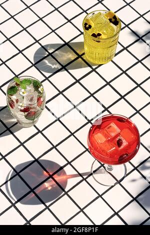 Set of colorful cocktails with sun shadows stand on the tiles. View from above. Stock Photo