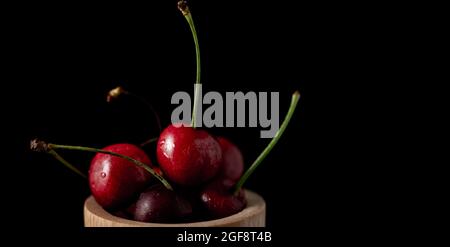 Popsicle with fresh cherries on a dark background, dynamic shot with action, splash, water drops and bokeh. Fresh fruit floating or levitating shotwit Stock Photo