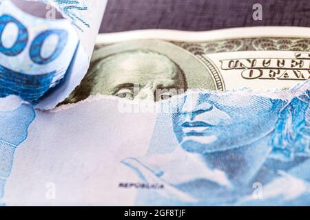 100 reais banknote from brazil revealing a hundred dollar bill, conceptual image of stock exchange, economy between usa and brazil Stock Photo