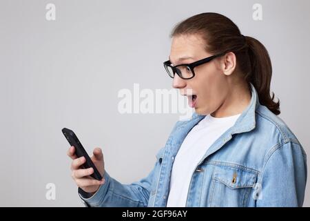 young man in glasses using smart phone Stock Photo