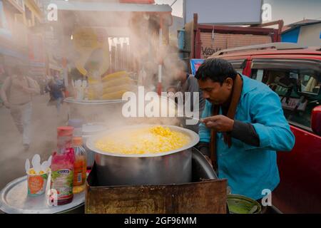 Kolkata, West Bengal, India - 29th December 2019 : Street vendor selling boiled baby corn on wheelcart to passer by customer. A popular vegetable stre Stock Photo