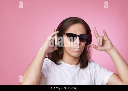 man in sunglasses listens to music with headphones and dances Stock Photo