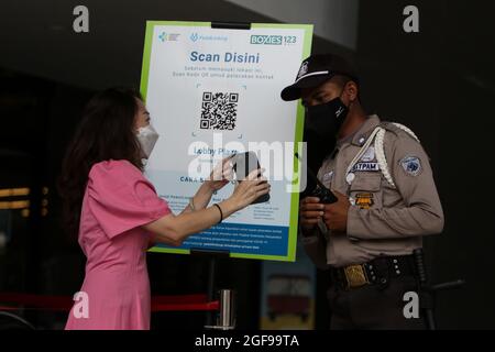 Bogor, Indonesia. 24th Aug, 2021. A officer mall check for QR codes identified COVID-19 vaccination certificate to a visitor at a shopping mall after the level public activity restrictions have been reduced from 4 to 3 in Bogor, West Java, Indonesia on August 24, 2021. (Photo by Adriana Adie/INA Photo Agency/Sipa USA) Credit: Sipa USA/Alamy Live News Stock Photo