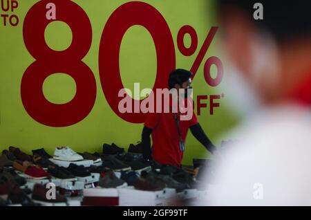 Bogor, Indonesia. 24th Aug, 2021. A worker at the outlet shoes at a shopping mall after the Indonesian government has allowed malls or shopping centers to reopen after the level public activity restrictions have been reduced from 4 to 3, in Bogor, West Java, Indonesia on August 24, 2021. (Photo by Adriana Adie/INA Photo Agency/Sipa USA) Credit: Sipa USA/Alamy Live News Stock Photo