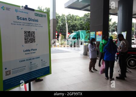 Bogor, Indonesia. 24th Aug, 2021. Shopper scans the QR code to enter a shopping mall after the Indonesian government has allowed malls or shopping centers to reopen after the level public activity restrictions have been reduced from 4 to 3, in Bogor, West Java, Indonesia on August 24, 2021. (Photo by Adriana Adie/INA Photo Agency/Sipa USA) Credit: Sipa USA/Alamy Live News Stock Photo