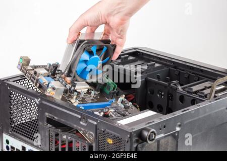 hand putting in or removing pc internals while maintenance personal computer hardware with selective focus Stock Photo