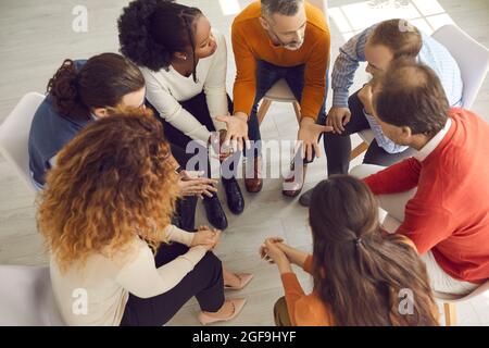 High angle shot of diverse people working on their problems in group therapy session Stock Photo