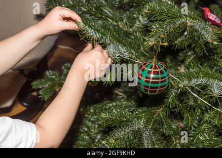 Close up view of child's hands holding glass ball for Christmas tree decoration. Sweden. Stock Photo