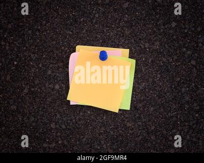 A lot of sticky notes pinned onto a cork board. Close up. Stock Photo