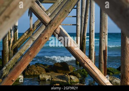 Landscape from Tuzla with the Black Sea, sand and rocks under a bridge made of logs Stock Photo