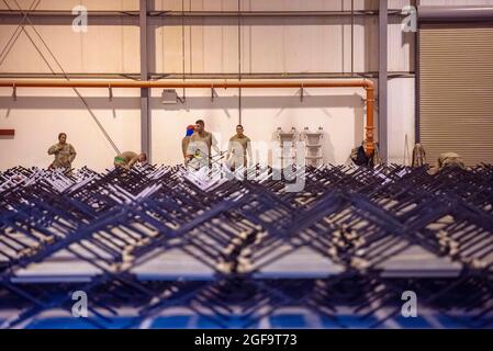 Al Udeied Air Base, Qatar. 22nd Aug, 2021. U.S. Air Force airmen assemble cots as they prepare a transit camp in support of Operation Allies Refuge August 22, 2021 at Al Udeid Air Base, Qatar. Credit: Planetpix/Alamy Live News Stock Photo