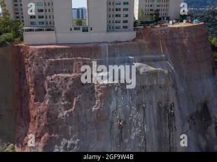 Workers reinforcing cliff under a high-rise building Santa Fe, Mexico City, Mexico Stock Photo