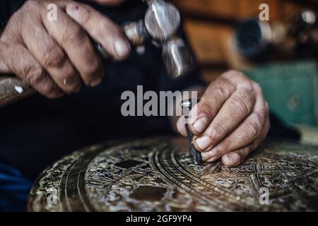 Algerian coppersmith in his workshop Stock Photo
