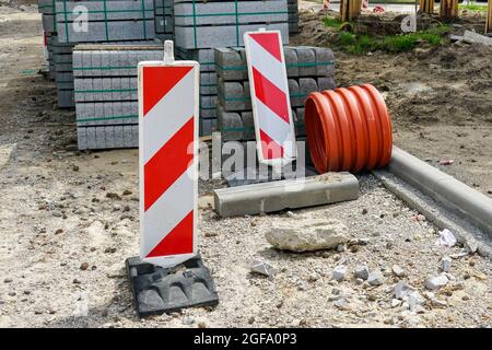 concrete curbs on wooden pallets stand on the street during street repair in city Stock Photo