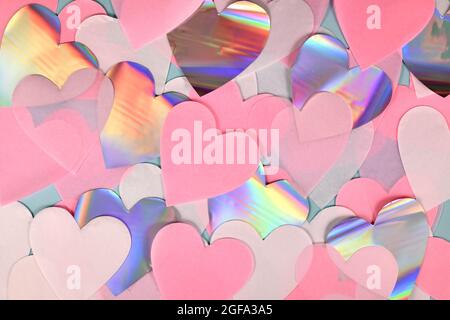 Pink, white and shiny silver colored heart shaped paper confetti on light blue background Stock Photo
