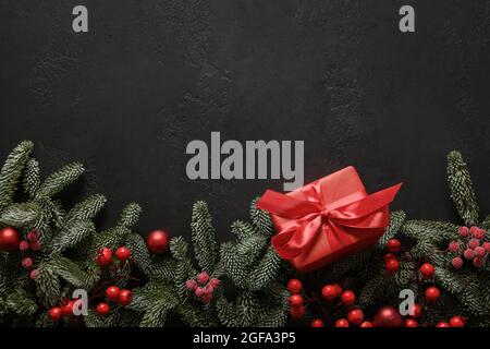 Christmas frame with red gift box and decorations on black background with copy space. Xmas greeting card. Winter Holiday. Happy New Year. View from a Stock Photo