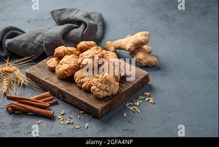 Homemade ginger cookies, ginger and cinnamon on a dark background. Side view, space for copying. Stock Photo