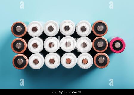 AA batteries are arranged in the form of a large battery on a blue background. Top view. The concept of energy supply and utilization Stock Photo