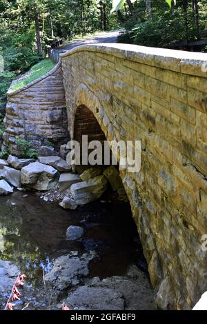 Stone CCC bridge arching over a creek at McCormick's Creek State Park, Indiana Stock Photo