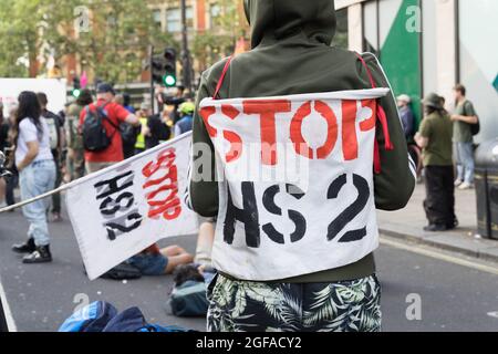 Cambridge Circus, London, UK. 24th August 2021. Climate change protesters from Extinction Rebellion siting at Cambridge Circus , blocking Charing Cross road along the way to Trafalgar Square. Credit: Xiu Bao/Alamy Live News Stock Photo