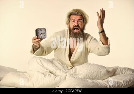 Stop ringing. time to wake up. early morning routine. bearded man in bed with alarm clock ringing. time management. need to relax. Annoying ringing Stock Photo