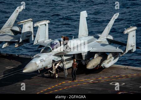 Arabian Sea, United States. 24th Aug, 2021. U.S. Navy sailors clean the canopy of an EA-18G Growler electronic attack aircraft, attached to the Shadowhawks of Electronic Attack Squadron 141, before take off on the flight deck of aircraft carrier USS Ronald Reagan August 24, 2021 in the Arabian Sea. Credit: Planetpix/Alamy Live News Stock Photo