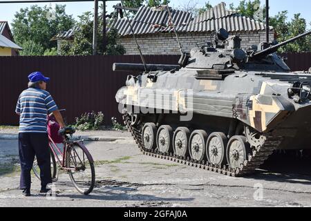 Marinka, Ukraine. 24th Aug, 2021. Elderly man looking at the infantry combat vehicle during the Independence Day.August 24th, Ukraine celebrates the 30th anniversary of its Independence in honor of the adoption by the Verkhovna Rada of the Ukrainian SSR in 1991 of the Act of Independence of Ukraine - a political and legal document that certified the new status of the Ukrainian State. Credit: SOPA Images Limited/Alamy Live News Stock Photo