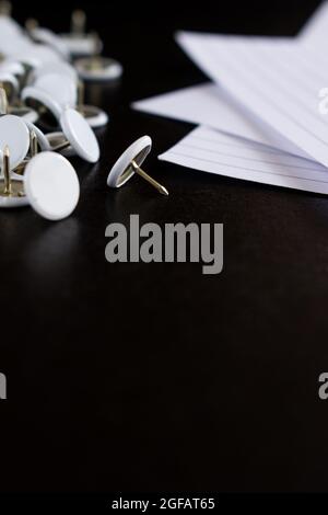 Office stuff like some sheets of paper and other white stationery on a black wooden table Stock Photo