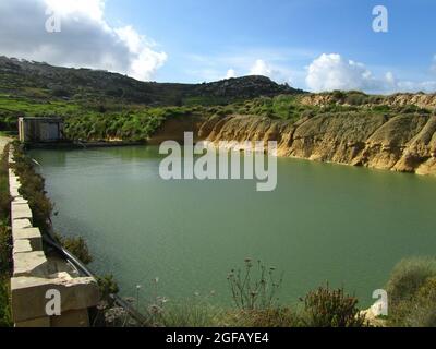 MGARR, MALTA - Feb 09, 2014: A large fresh water reservoir among arable rural land in the countryside of Mgarr, Malta Stock Photo