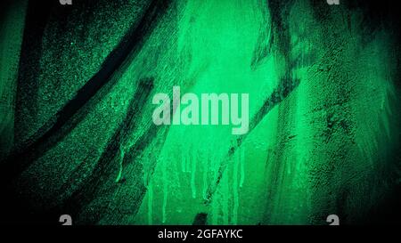 Gloomy background with cracked paint in neon green. Copy space. Abstract background, texture of acrylic paints. Artistic wall. Halloween background Stock Photo