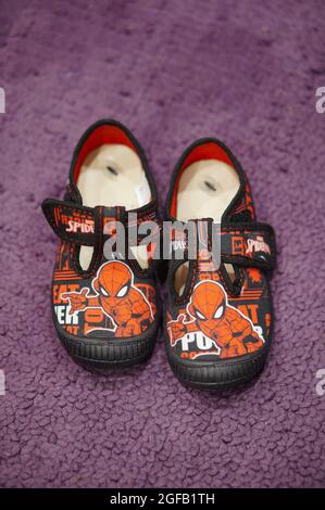 POZNAN, POLAND - Mar 29, 2018: A vertical shot of kids' spiderman slippers on a purple carpet Stock Photo