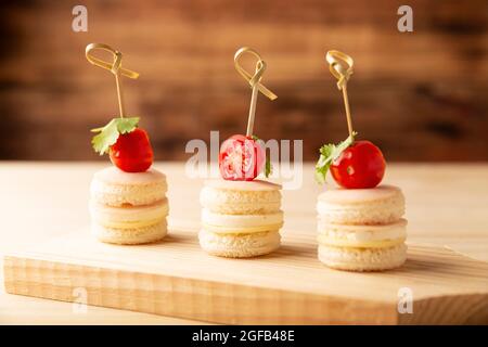 Close up of Delicious Party Snacks. Round mini sandwiches with ham and cheese decorated with cherry tomato on a bamboo stick Stock Photo