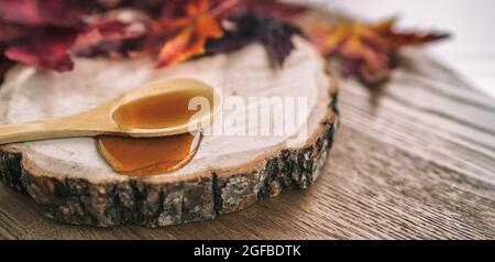 Maple syrup sugar shack cabane a sucre restaurant from Quebec farm maple tree sap famous sweet liquid dripping from wooden spoon on wood log. Rustic Stock Photo