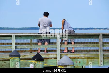 Kent Island, Maryland, U.S.A - August 15, 2021 - Two guys crabbing on Romancoke fishing pier in the hot summer day Stock Photo