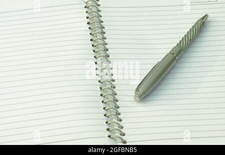 Close up of pen placed on spiral notebook. Full frame shot. High angle view. Business education background. Stock Photo
