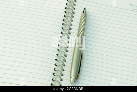 Close up of pen placed on spiral notebook. Full frame shot. High angle view. Business education background. Stock Photo