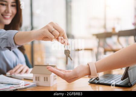 Client taking keys from female real estate agent during meeting after signing rental lease contract or sale purchase agreement. Independent woman Stock Photo