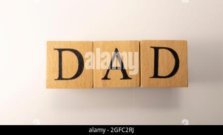 The word Dad was crafted from wooden cubes. Kinship and people. Close-up. Stock Photo