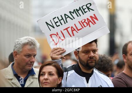 Vienna, Austria. 24th August, 2021. Demonstration human rights are non-negotiable, in solidarity with the people of Afghanistan. Petar Rosandic aka Kid Pex holds a plaque with the inscription 'Nehammer (Austrian Minister of the Interior) you Taliban'. Stock Photo