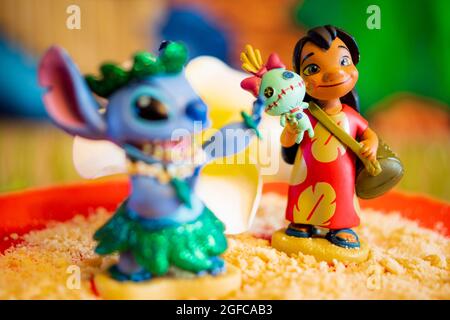New York, USA - June 25, 2021: Close-up shot of Lilo figure in Background and in Focus and Stitch blurred out in foreground on a molded cake. Stock Photo