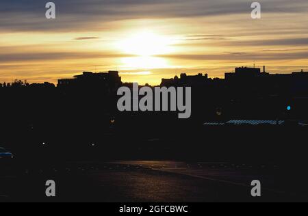 Urban skyline of a city at sunset with dramatic sky and dark foreground with copy space Stock Photo
