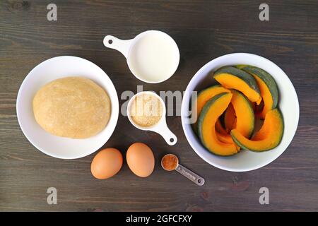 Top View of the Ingredients for Baking Fresh Pumpkin Pie on the Black Wooden Background Stock Photo