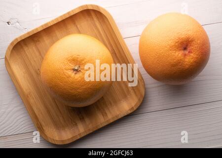 Two juicy organic grapefruits, close-up, on a wooden table, top view. Stock Photo